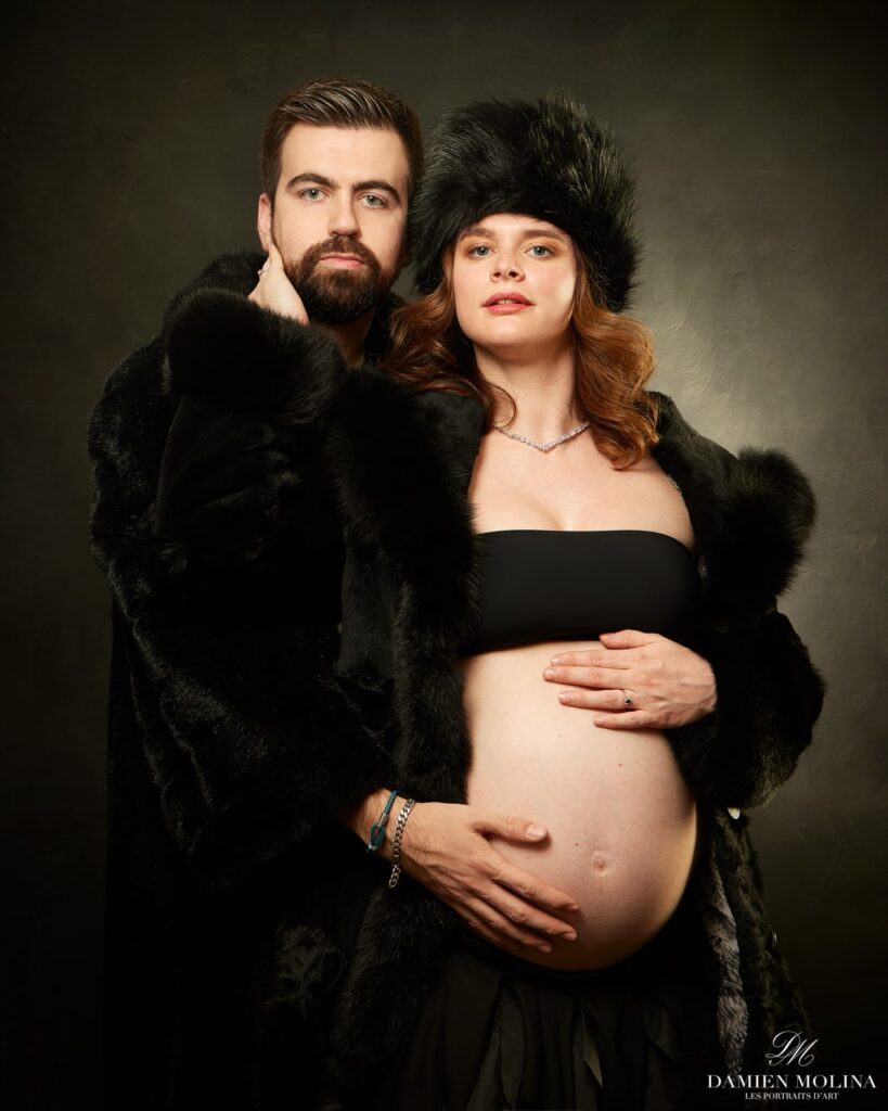 Portrait de grossesse : Élégance et chaleur à Strasbourg - Damien Molina - Photographe Photo artistique d'un couple attendant un enfant, la future maman vêtue d'une tenue noire avec un manteau de fourrure, capturée lors d'une séance grossesse à Strasbourg.