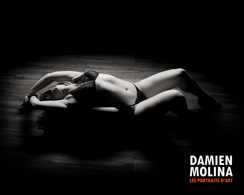 Photo boudoir clair-obscur artistique - Damien Molina - Damien Molina - Photographe Femme allongée au sol en lingerie noire, clair-obscur noir et blanc - photo boudoir artistique Strasbourg